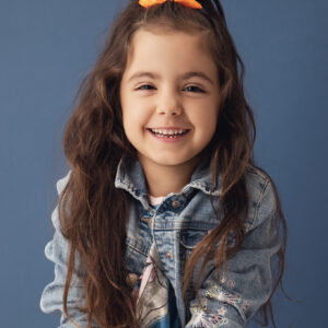 Portrait enfant en studio sur un fond bleu avec une veste en jeans