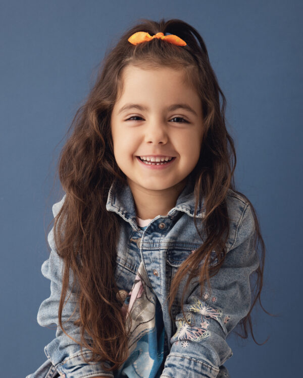 Portrait enfant en studio sur un fond bleu avec une veste en jeans